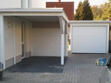 Einzelnes Carport mit einer Aluminium-Kante und einem Garagentor hinter dem Carport – in Detmold