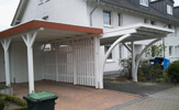 Einzel-Carport aus BSH Leimholz mit Leimbinder-Bogen, 12/12 Pfosten, Fundamenten und einer Aluminiumkante– in Bielefeld