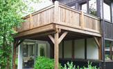 Holz-Balkon aus Lärche mit Geländer und Handlauf, Zink-Pfostenkappen und Fußboden